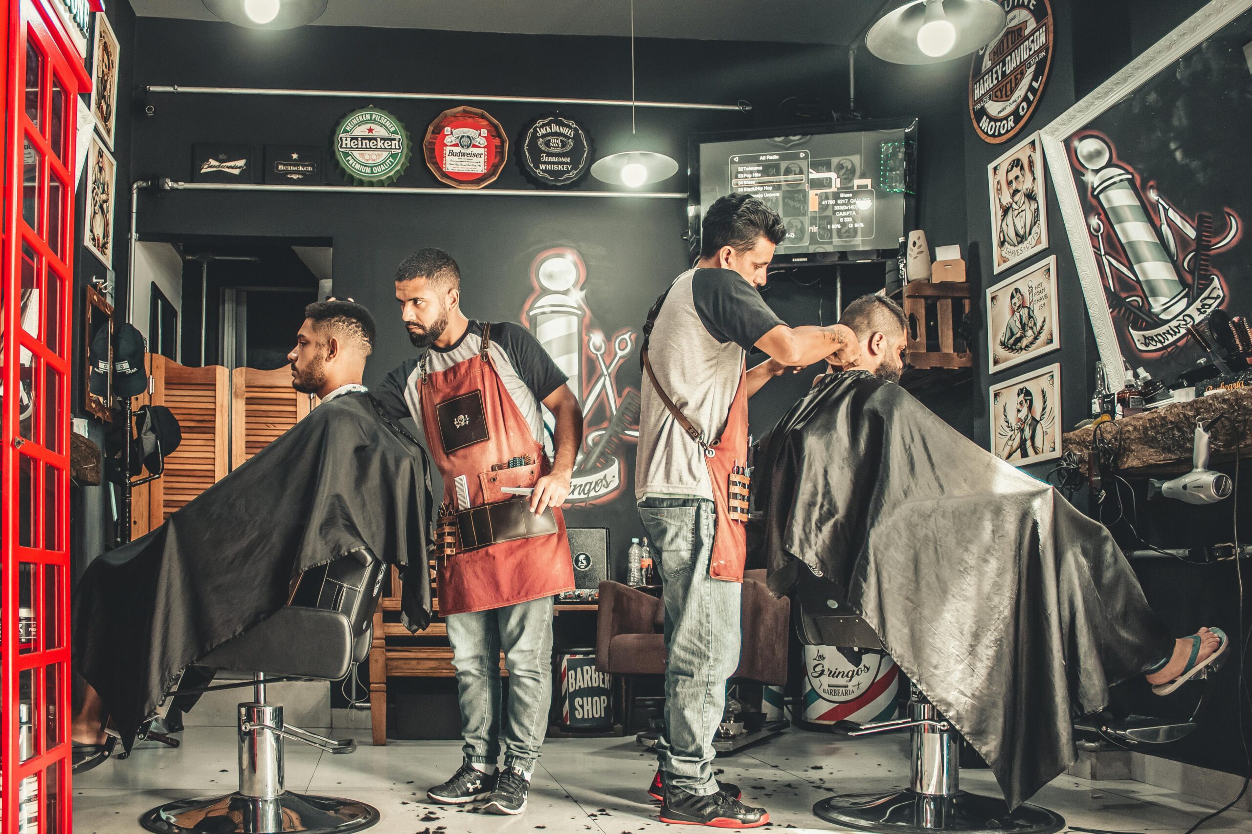 A bustling barbershop with two men getting haircuts, showcasing a vibrant barber environment.